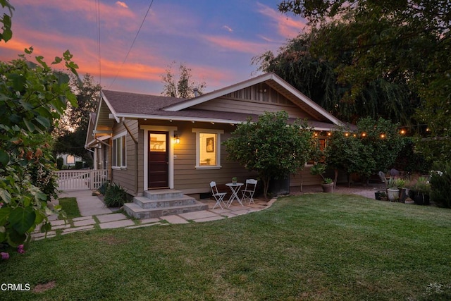 1036 N Chester Ave, Pasadena, CA 91104 - back of house at dusk with a lawn, a patio, and roof with shingles