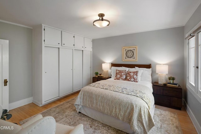 1036 N Chester Ave, Pasadena, CA 91104 - bedroom featuring crown molding, multiple windows, light wood-style flooring, and a closet