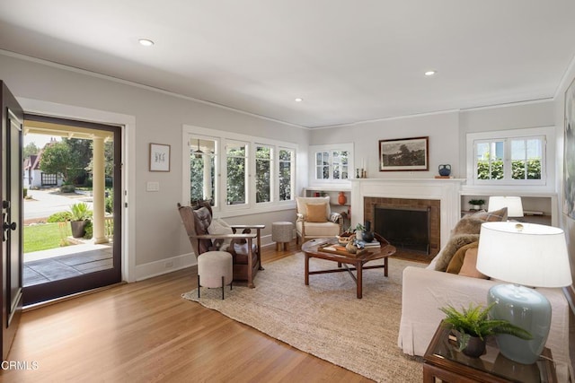 1036 N Chester Ave, Pasadena, CA 91104 - living area with plenty of natural light, a brick fireplace, light wood-type flooring, ornamental molding, and recessed lighting