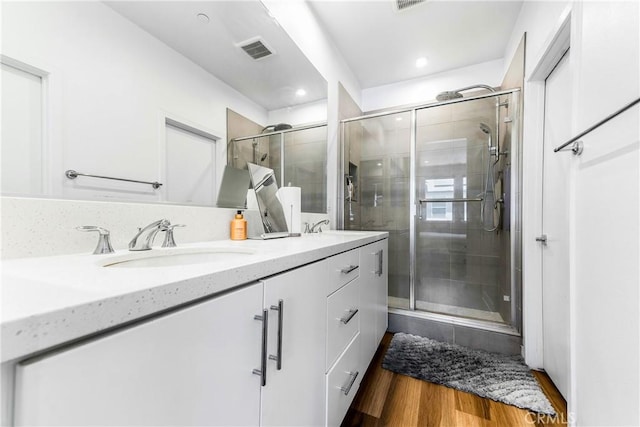 1206 W Cara Dr, Anaheim, CA 92805 - bathroom featuring double vanity, a stall shower, wood finished floors, and recessed lighting