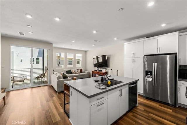1206 W Cara Dr, Anaheim, CA 92805 - kitchen with stainless steel appliances, dark wood-type flooring, an island with sink, recessed lighting, and white cabinets