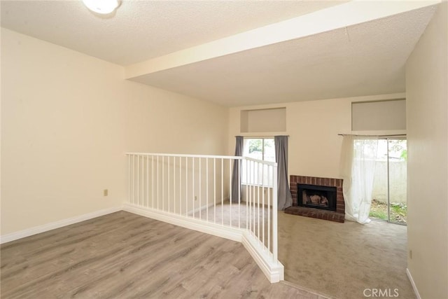 3342 Darby St Unit 317, Simi Valley, CA 93063 - empty room with wood finished floors, a fireplace, and beamed ceiling