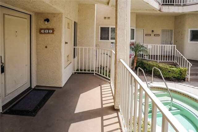3342 Darby St Unit 317, Simi Valley, CA 93063 - doorway to property with a pool, stucco siding, a balcony, and a community hot tub