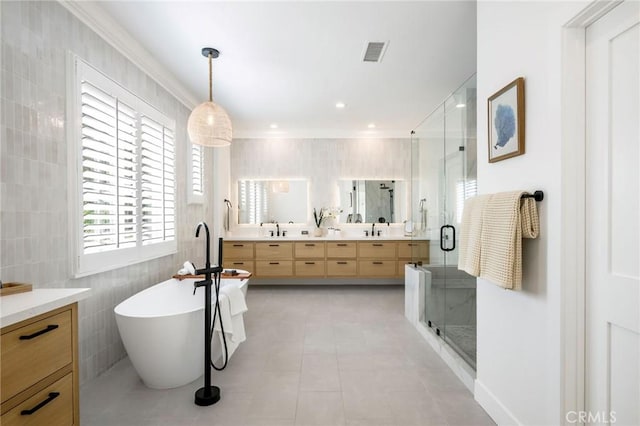 308 Via El Patio, San Clemente, CA 92673 - bathroom with tile walls, double vanity, a shower stall, a soaking tub, and ornamental molding