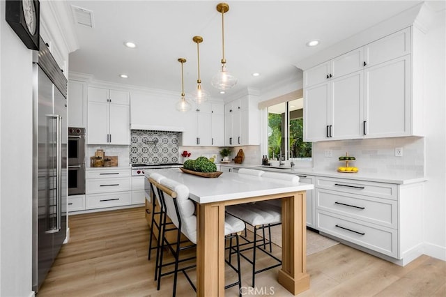 308 Via El Patio, San Clemente, CA 92673 - kitchen featuring stainless steel appliances, a kitchen breakfast bar, light countertops, light wood finished floors, and recessed lighting
