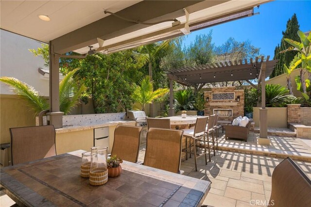 308 Via El Patio, San Clemente, CA 92673 - view of patio with an outdoor stone fireplace, exterior bar, a pergola, outdoor dining area, and an outdoor kitchen