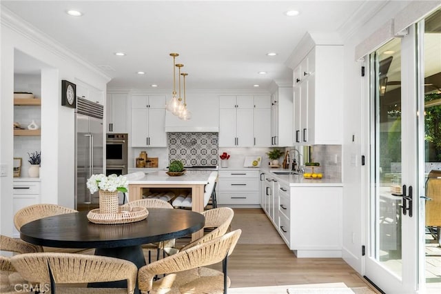 308 Via El Patio, San Clemente, CA 92673 - kitchen featuring light countertops, decorative backsplash, light wood-style flooring, white cabinetry, and stainless steel appliances