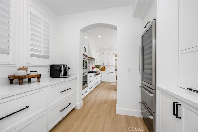 308 Via El Patio, San Clemente, CA 92673 - kitchen featuring arched walkways, light wood-style floors, white cabinets, recessed lighting, and light countertops