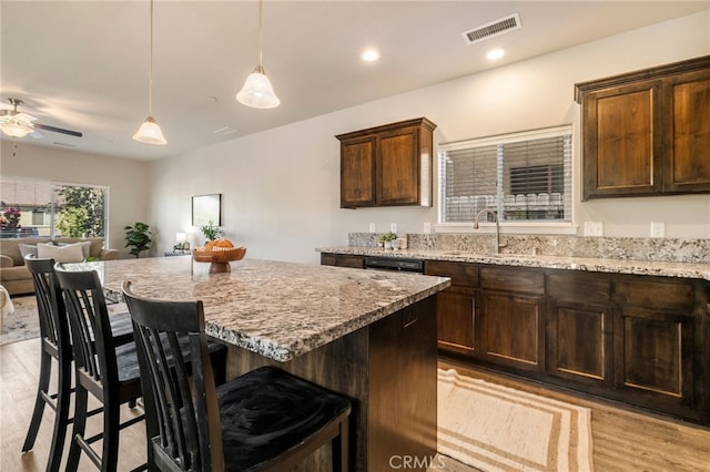 2740 Levi Ln, Chico, CA 95973 - kitchen with a breakfast bar, light wood-style floors, light stone counters, ceiling fan, and recessed lighting