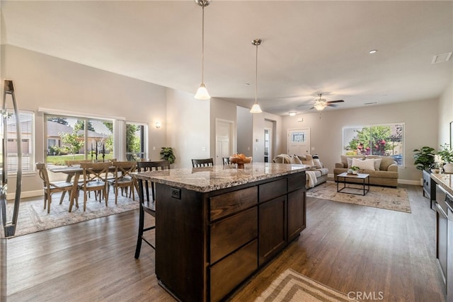 2740 Levi Ln, Chico, CA 95973 - kitchen featuring dark wood-style flooring, dark brown cabinetry, a ceiling fan, pendant lighting, and a kitchen island