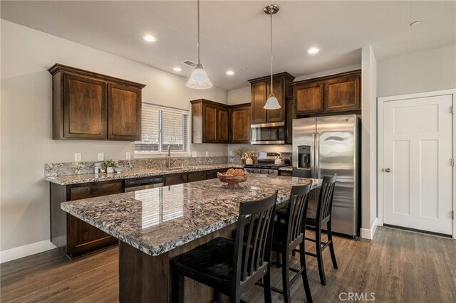 2740 Levi Ln, Chico, CA 95973 - kitchen featuring stainless steel appliances, dark brown cabinetry, dark wood finished floors, dark stone countertops, and recessed lighting