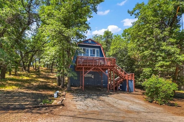 1351 Silverado Rd, Big Bear City, CA 92314 - view of front of property with concrete driveway, stairway, a wooden deck, a carport, and a gambrel roof