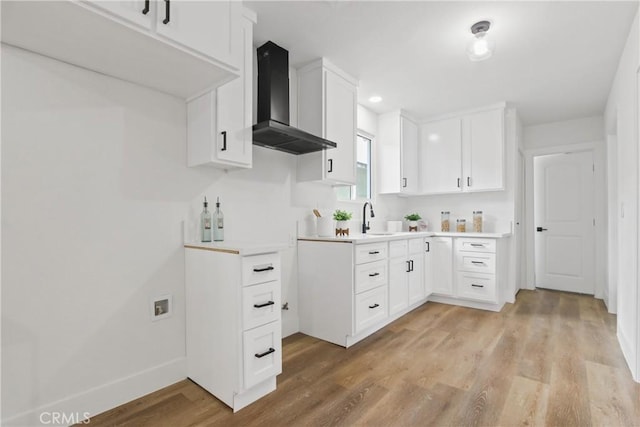 9525 Holmes Ave, Los Angeles, CA 90002 - kitchen with wall chimney range hood, light wood-type flooring, light countertops, white cabinets, and recessed lighting