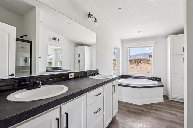 537 Calaveras Rd, Pinon Hills, CA 92372 - full bathroom with double vanity, a garden tub, a shower stall, and wood finished floors