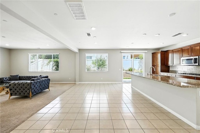 6212 Athena St, Chino, CA 91710 - kitchen with appliances with stainless steel finishes, open floor plan, light tile patterned floors, light stone counters, and light carpet