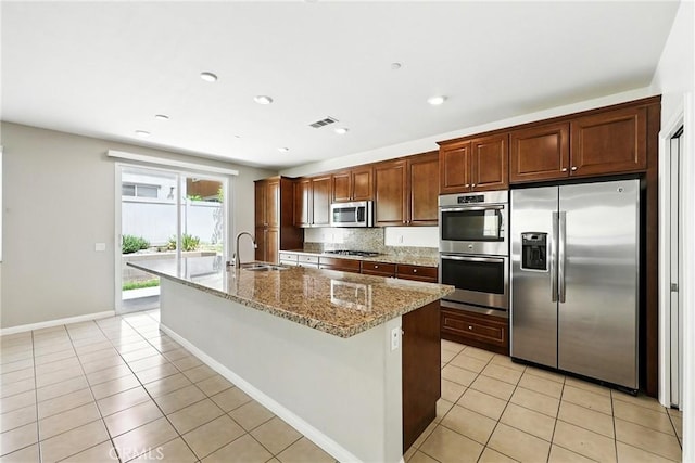 6212 Athena St, Chino, CA 91710 - kitchen featuring stainless steel appliances, light tile patterned floors, a kitchen island with sink, light stone countertops, and recessed lighting