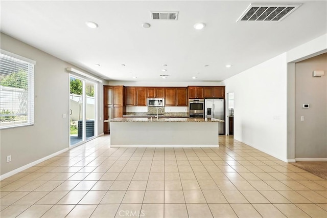 6212 Athena St, Chino, CA 91710 - kitchen featuring appliances with stainless steel finishes, an island with sink, recessed lighting, light stone countertops, and light tile patterned floors