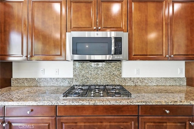 6212 Athena St, Chino, CA 91710 - kitchen featuring appliances with stainless steel finishes, light stone countertops, and backsplash