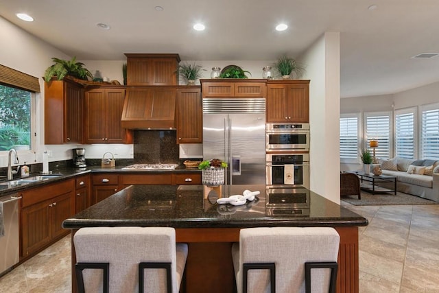 674 Calypso Pl, Encinitas, CA 92024 - kitchen featuring appliances with stainless steel finishes, dark stone countertops, tasteful backsplash, a kitchen island, and recessed lighting