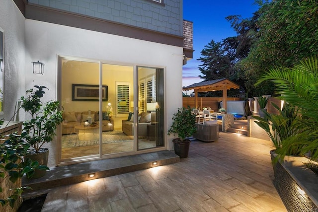 674 Calypso Pl, Encinitas, CA 92024 - exterior entry at dusk with stucco siding, a patio, and an outdoor living space
