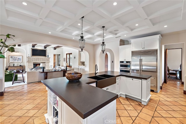 1 Overlook Dr, Ladera Ranch, CA 92694 - kitchen with appliances with stainless steel finishes, dark countertops, arched walkways, a large island, and coffered ceiling