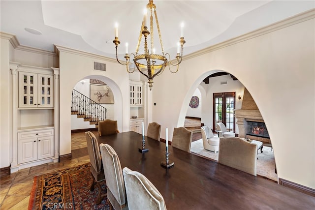 1 Overlook Dr, Ladera Ranch, CA 92694 - dining area featuring arched walkways, a chandelier, stairway, a glass covered fireplace, and crown molding