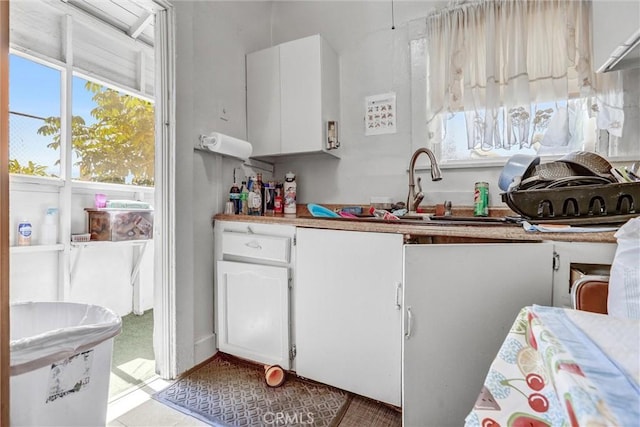 1470 W Adams Blvd, Los Angeles, CA 90007 - kitchen featuring white cabinetry, plenty of natural light, light countertops, and light tile patterned floors