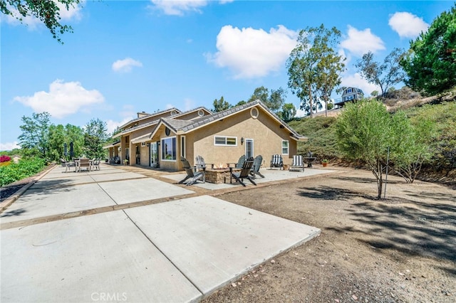 33612 Vino Way, Temecula, CA 92591 - rear view of house featuring a fire pit, a patio area, and stucco siding