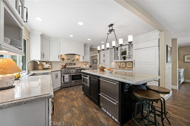 33612 Vino Way, Temecula, CA 92591 - kitchen with range with two ovens, white cabinets, a kitchen breakfast bar, dark cabinetry, and glass insert cabinets