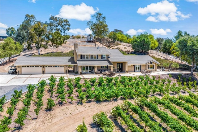 33612 Vino Way, Temecula, CA 92591 - view of front of home featuring driveway, an attached garage, a chimney, and a patio area