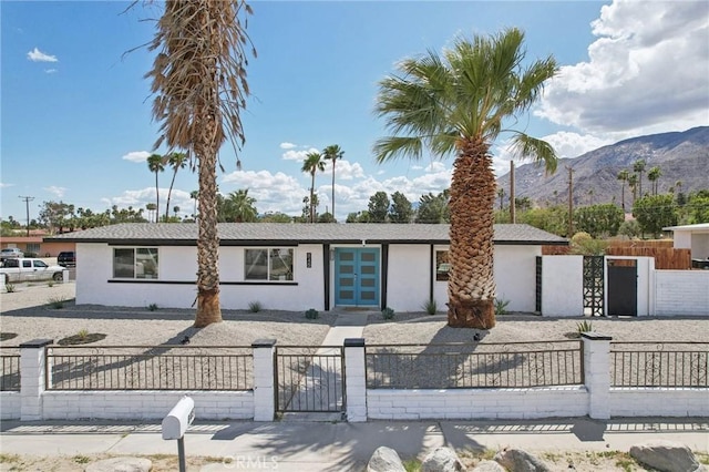 845 W Gateway Dr, Palm Springs, CA 92262 - view of front facade featuring stucco siding, a mountain view, a fenced front yard, and a gate