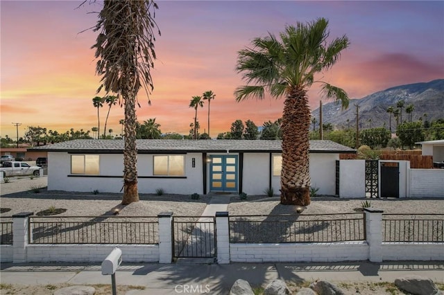 845 W Gateway Dr, Palm Springs, CA 92262 - view of front of property with stucco siding, a mountain view, a gate, and a fenced front yard
