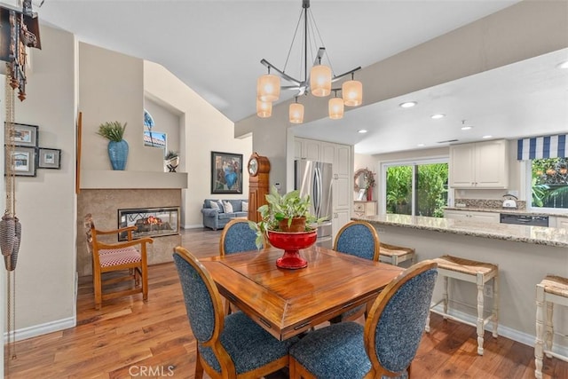 239 Via Presa, San Clemente, CA 92672 - dining space featuring light wood finished floors, recessed lighting, lofted ceiling, and a multi sided fireplace