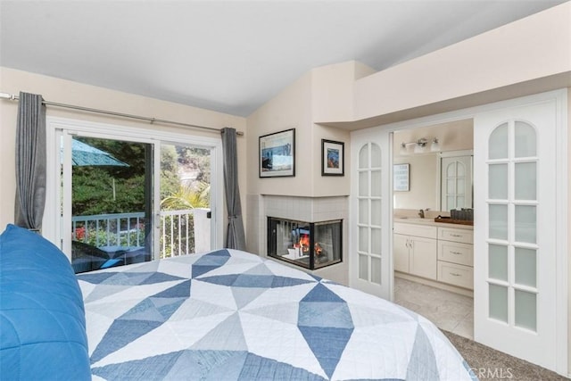 239 Via Presa, San Clemente, CA 92672 - bedroom featuring access to exterior, vaulted ceiling, connected bathroom, a multi sided fireplace, and light tile patterned flooring