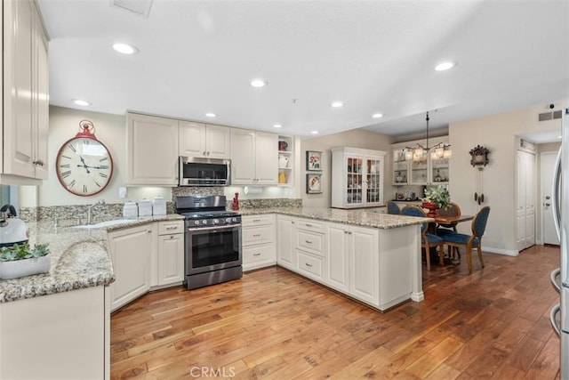 239 Via Presa, San Clemente, CA 92672 - kitchen featuring stainless steel appliances, light wood-type flooring, a peninsula, light stone counters, and recessed lighting