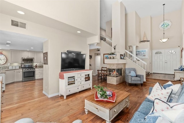 239 Via Presa, San Clemente, CA 92672 - living area featuring high vaulted ceiling, light wood-type flooring, stairs, recessed lighting, and a multi sided fireplace