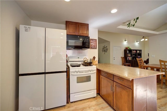 4887 Arizona Ave, Atascadero, CA 93422 - kitchen featuring white appliances, a peninsula, light wood-type flooring, brown cabinets, and light countertops