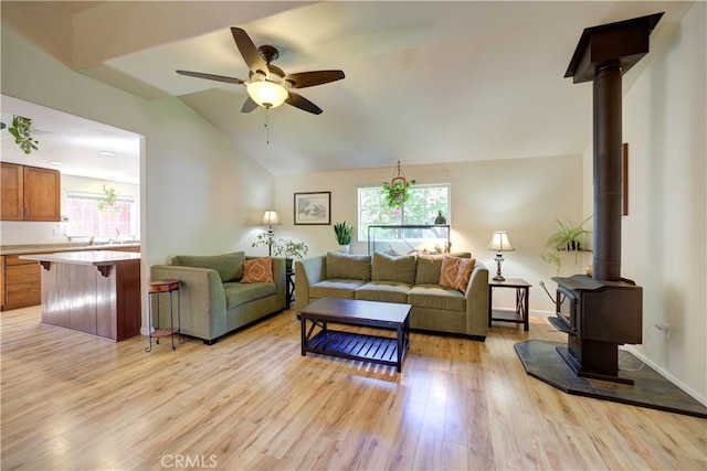4887 Arizona Ave, Atascadero, CA 93422 - living area with a wood stove, light wood-style flooring, healthy amount of natural light, vaulted ceiling, and ceiling fan