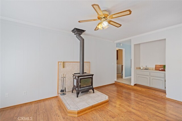 50128 Deer Meadow Way, Oakhurst, CA 93644 - unfurnished living room with a wood stove, ornamental molding, light wood-style floors, and ceiling fan