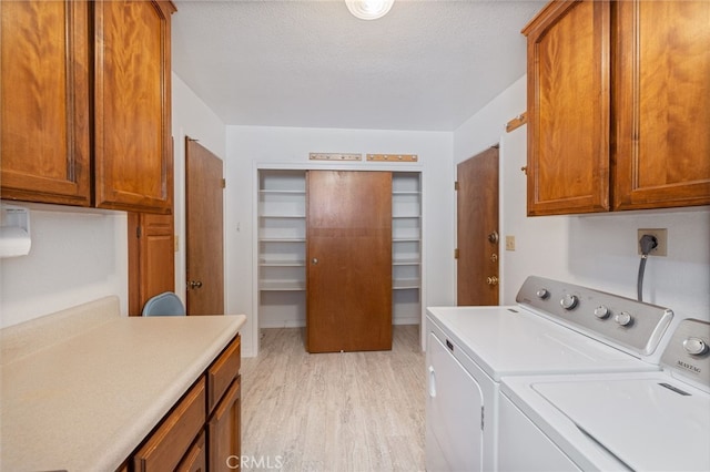 50128 Deer Meadow Way, Oakhurst, CA 93644 - laundry area featuring washer and clothes dryer, cabinet space, light wood-style flooring, and a textured ceiling