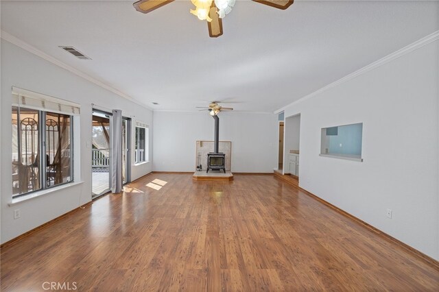 50128 Deer Meadow Way, Oakhurst, CA 93644 - unfurnished living room with a ceiling fan, a wood stove, ornamental molding, and wood finished floors