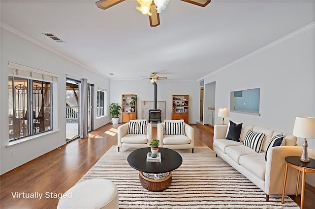 50128 Deer Meadow Way, Oakhurst, CA 93644 - living room featuring a ceiling fan, a wood stove, ornamental molding, and wood finished floors
