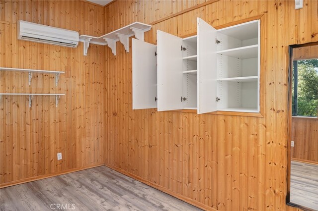 50128 Deer Meadow Way, Oakhurst, CA 93644 - empty room featuring a wall mounted AC, wooden walls, and wood finished floors