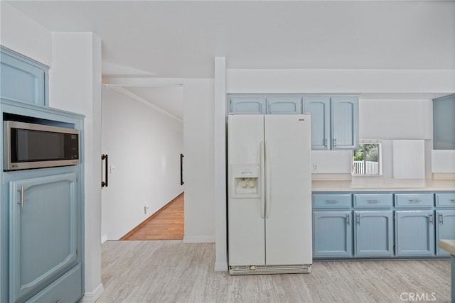 50128 Deer Meadow Way, Oakhurst, CA 93644 - kitchen with white fridge with ice dispenser, stainless steel microwave, light wood-type flooring, light countertops, and blue cabinetry