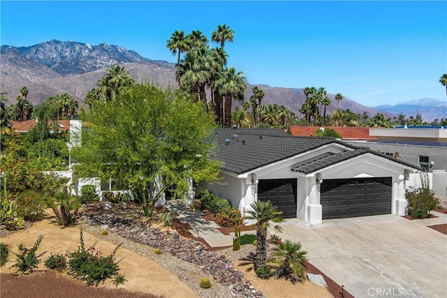 1525 Sonora Ct, Palm Springs, CA 92264 - view of front of property featuring an attached garage, a tile roof, a mountain view, stucco siding, and driveway