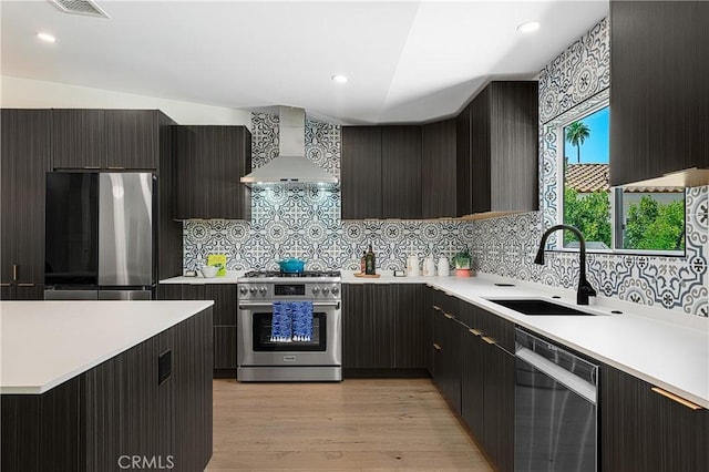 1525 Sonora Ct, Palm Springs, CA 92264 - kitchen with wall chimney exhaust hood, appliances with stainless steel finishes, light countertops, backsplash, and modern cabinets