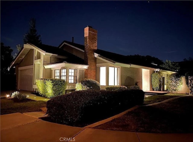 2 Brookstone, Irvine, CA 92604 - property exterior at night featuring an attached garage and a chimney