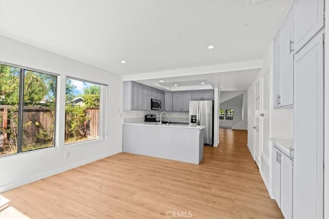 2 Brookstone, Irvine, CA 92604 - kitchen featuring stainless steel appliances, light wood finished floors, a peninsula, light countertops, and recessed lighting