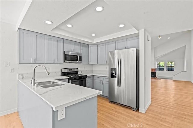 2 Brookstone, Irvine, CA 92604 - kitchen with stainless steel appliances, gray cabinetry, a peninsula, light stone countertops, and recessed lighting