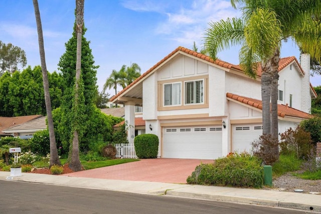 2702 Jacaranda Ave, Carlsbad, CA 92009 - view of front of house with a tile roof, a garage, driveway, stucco siding, and board and batten siding